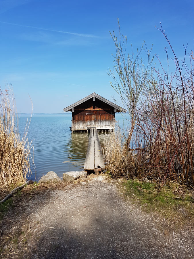 Chiemsee lake in Germany day trip in the spring, Bavarian lake trip, old wooden pier and house
