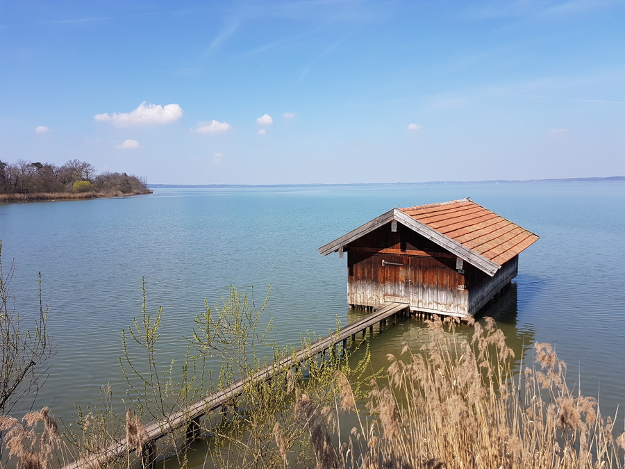 Chiemsee lake in Germany day trip in the spring, Bavarian lake trip peaceful pier and wooden house